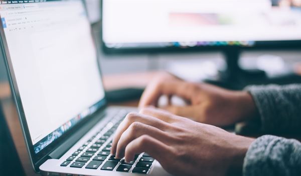 hands typing on a laptop